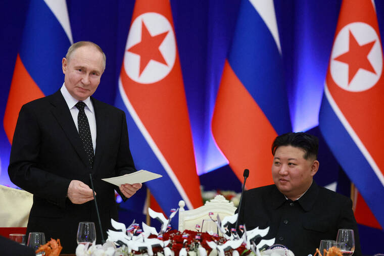 SPUTNIK/VLADIMIR SMIRNOV/POOL VIA REUTERS
                                Russia’s President Vladimir Putin and North Korea’s leader Kim Jong Un attend a state reception in Pyongyang, North Korea, on June 19. Putin signed into law a treaty on the country’s strategic partnership with North Korea, which includes a mutual defense provision, according to a decree published on Saturday.