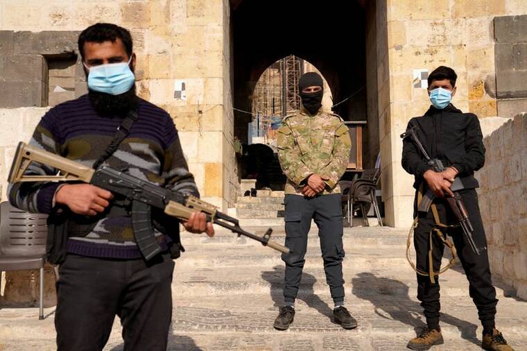 KARAM al-MASRI / REUTERS
                                Rebel fighters holds weapons Monday at the Citadel of Aleppo, in Aleppo, Syria, after rebels ousted President Bashar al-Assad over the weekend, ending a 13-year civil war.