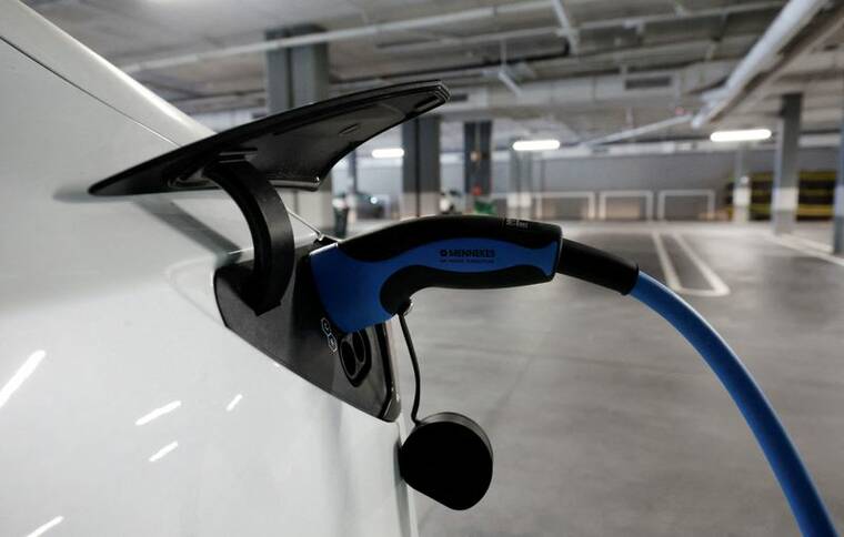 REUTERS/ALBERT GEA/FILE PHOTO
                                A Tesla electric vehicle is plugged into a charger in a parking lot in Teia, north of Barcelona, Spain, in October 2023.