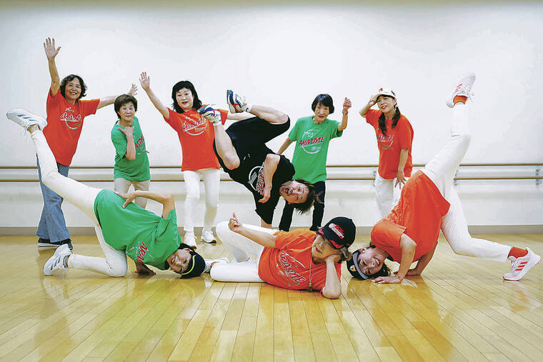 KYUNG HOON KIM / REUTERS
                                Members pose for a picture after a final rehearsal for a performance at a Tokyo festival. Their instructor, Yusuke Arai, 38, in the black shirt, joins them.