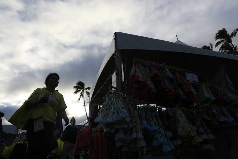 JAMM AQUINO / JAQUINO@STARADVERTISER.COM
                                A shopper is silhouetted during the 10th annual Made in Maui County Festival on Nov. 3 in Kahului.