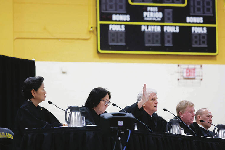 GEORGE F. LEE / GLEE@STARADVERTISER.COM
                                The state Supreme Court made an appearance in the Mililani High School gym on Tuesday to hear the case of Blosson Bell v. Hawaii Public Housing Authority. The sitting justices were Lisa M. Ginoza, left, Sabrina S. McKenna, Chief Justice Mark Reck­tenwald, Todd W. Eddins and Vladimir P. Devens. At bottom, Klemen Urbanc, deputy attorney general, addressed the court.